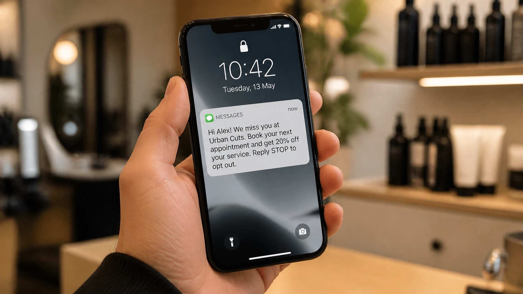 Smartphone displaying an SMS reminder for a customer reactivation campaign from a local business