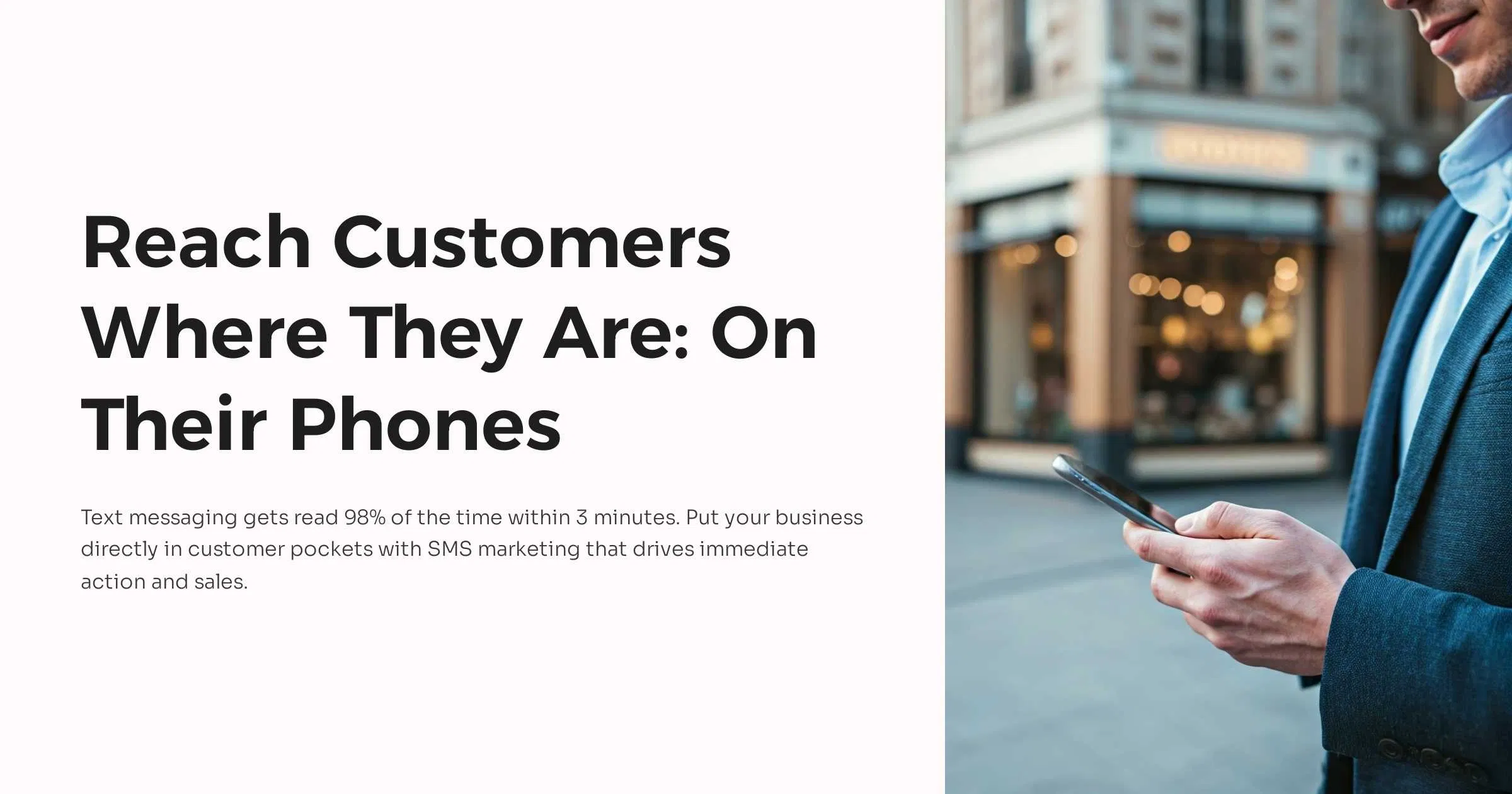 Professional holding a smartphone in a downtown setting, highlighting instant SMS communication for businesses.